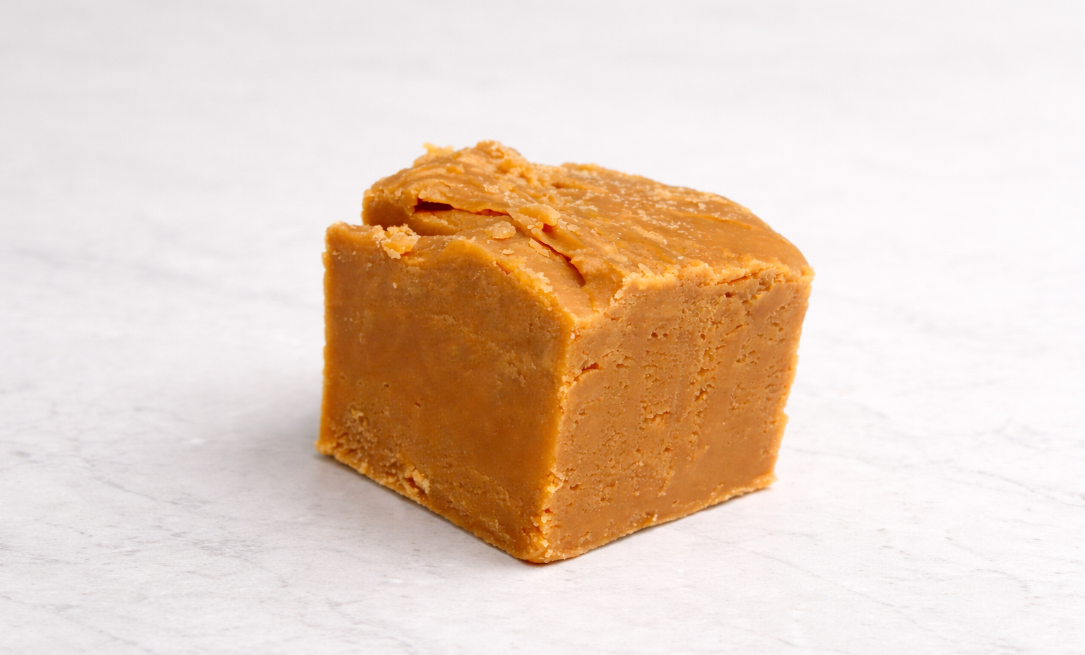 Block of Caramel butter fudge on a white background